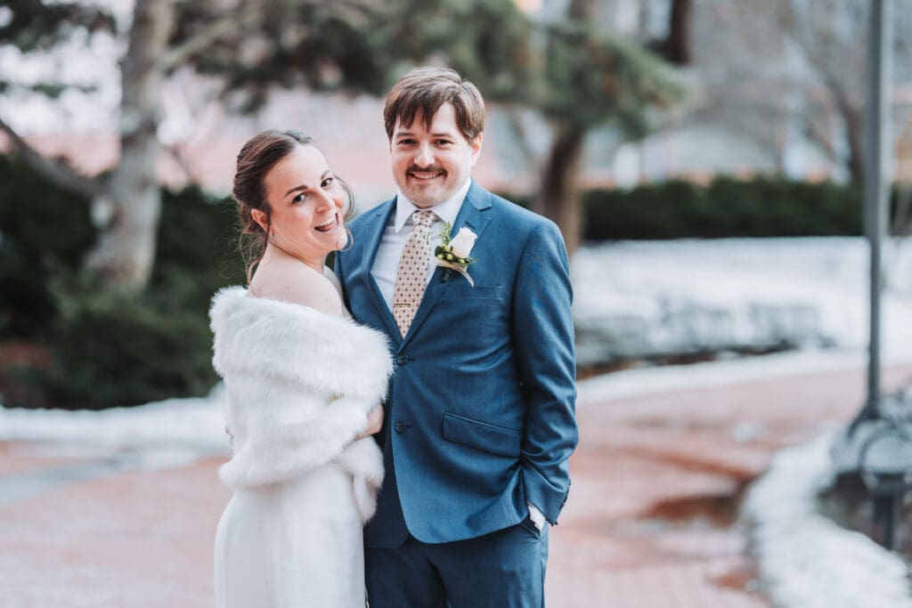 Bride and groom laughing together outside after their courthouse elopement at the Hennepin County Government Center in Minneapolis, Minnesota winter wedding photography by Eric Turner