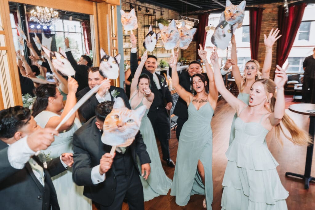 Wedding party celebrating with cat face cutouts at a Watson Block reception in Minneapolis — wedding photography by Eric Turner Photography, Minneapolis wedding photographer