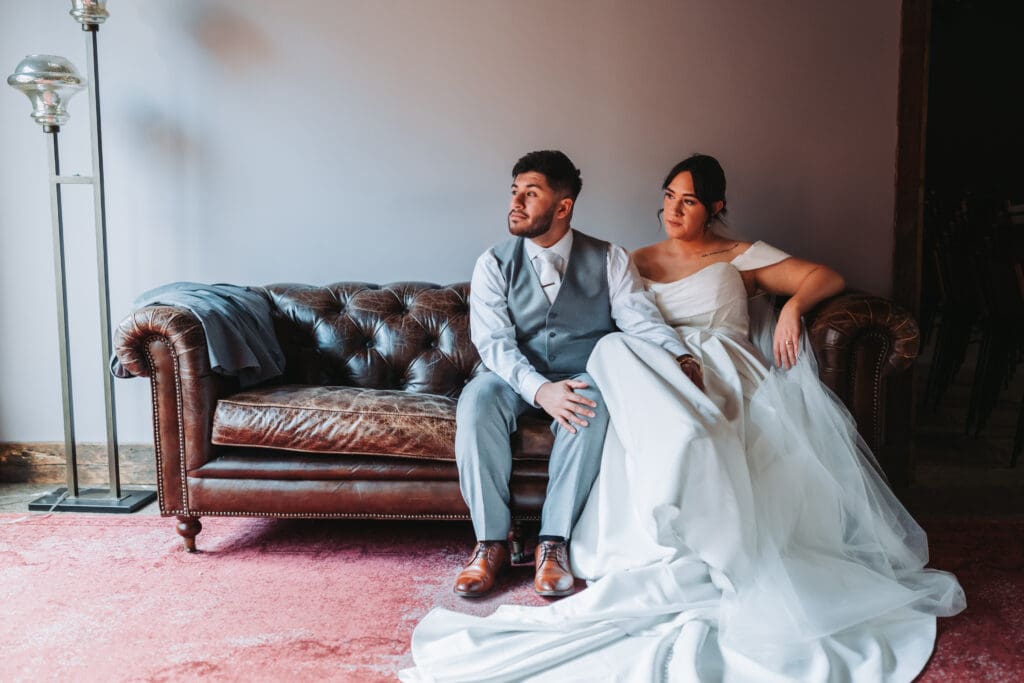 Bride and groom sitting together on a leather couch at Watson Block in Minneapolis — wedding portrait photography by Eric Turner Photography, Minneapolis wedding photographer